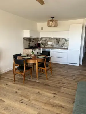 a kitchen with a table and chairs in a room at APPARTEMENT Rénové de type 3 VUE MER in Port-la-Nouvelle