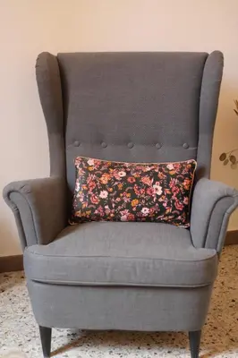 a gray chair with a floral pillow on it at Chez Céline, plein centre ville in Narbonne