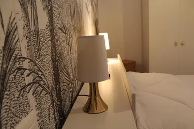 a lamp sitting on a table next to a bed at Chez Céline, plein centre ville in Narbonne