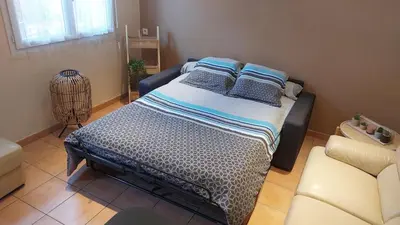 a bedroom with a bed and a couch and a chair at Charmant T2 à 5min des plages in Port-la-Nouvelle