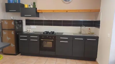a kitchen with a stove and a sink and a refrigerator at Charmant T2 à 5min des plages in Port-la-Nouvelle