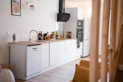 a kitchen with white cabinets and a sink at Hygge en Méditerranée in Salses-le-Chateau