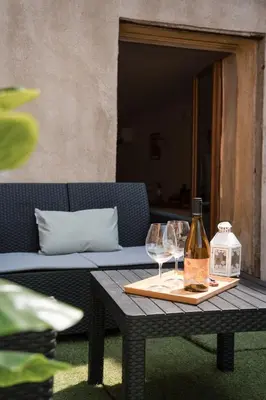 a table with two glasses and a bottle of wine at Hygge en Méditerranée in Salses-le-Chateau
