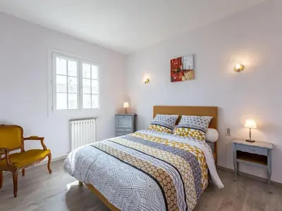 a bedroom with a bed and a chair and a window at Maison des Artistes - Centre Ville in Narbonne
