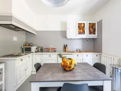 a kitchen with a table with a bowl of fruit on it at Maison des Artistes - Centre Ville in Narbonne