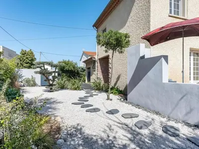 a garden with a walkway in front of a house at Maison des Artistes - Centre Ville in Narbonne
