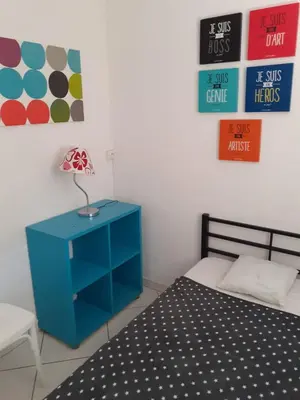 a bedroom with a blue nightstand next to a bed at Villa proche de la plage in Port-la-Nouvelle