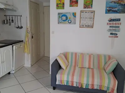 a living room with a couch and a kitchen at Villa proche de la plage in Port-la-Nouvelle