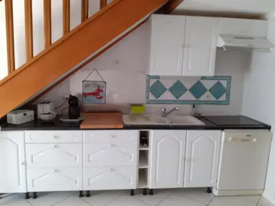 a kitchen with white cabinets and a sink at Villa proche de la plage in Port-la-Nouvelle