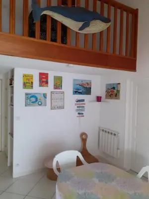 a room with a table and some pictures on the wall at Villa proche de la plage in Port-la-Nouvelle