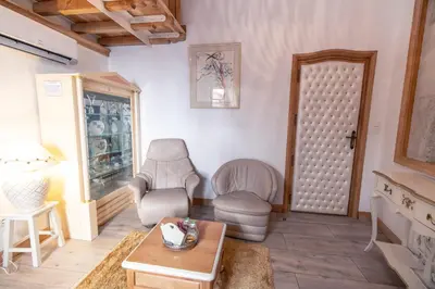a living room with two chairs and a table at Chambre romantique du Couvent in Narbonne