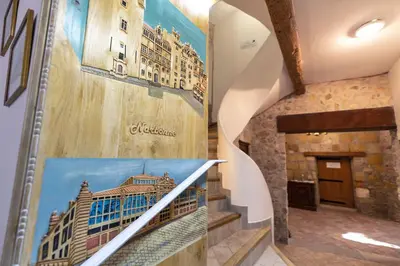 a hallway with a staircase with a picture of a building at Chambre romantique du Couvent in Narbonne