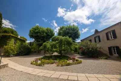 a garden with a tree and flowers in a courtyard at Appartement dans l'aile du château 130M2 6 personnes in Carcassonne