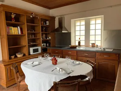 a kitchen with a table with a white table cloth at Appartement dans l'aile du château 130M2 6 personnes in Carcassonne