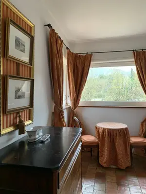 a living room with a table and a window at Appartement dans l'aile du château 130M2 6 personnes in Carcassonne
