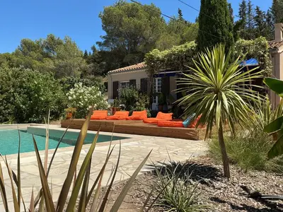 a backyard with a pool and orange chairs and a house at Le Doul Jolie villa au calme climatisée grande piscine jardin in Peyriac-de-Mer