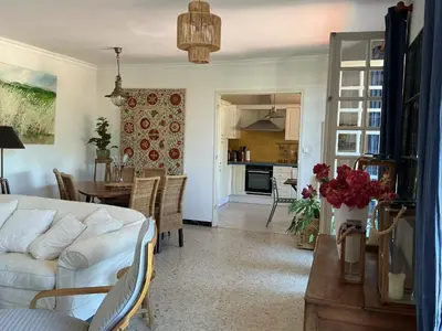 a living room with a white couch and a table at Le Doul Jolie villa au calme climatisée grande piscine jardin in Peyriac-de-Mer