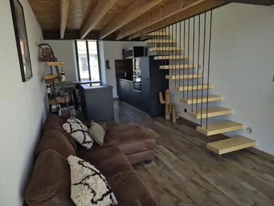 a living room with a couch and a staircase at Apartement La Cuverie in Carcassonne