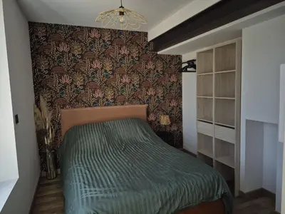 a bedroom with a bed with a green comforter at Apartement La Cuverie in Carcassonne