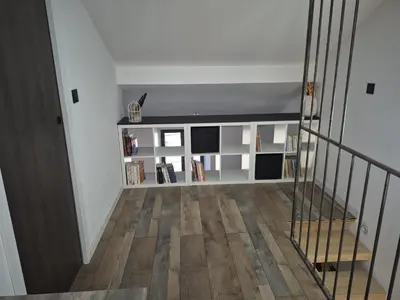 a hallway with a staircase with a book shelf at Apartement La Cuverie in Carcassonne