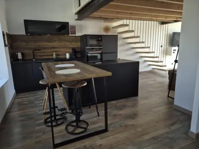 a kitchen with a table with stools and a staircase at Apartement La Cuverie in Carcassonne