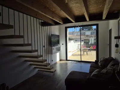a living room with a staircase and a couch at Apartement La Cuverie in Carcassonne