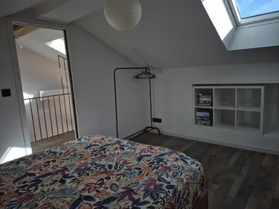 a bedroom with a bed in a room with windows at Apartement La Cuverie in Carcassonne