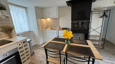 a kitchen with a table with yellow flowers on it at My Agradi, Maison de village in Les Martys