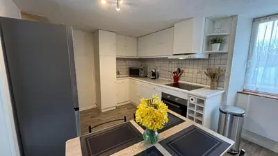 a kitchen with a table with a vase of yellow flowers at My Agradi, Maison de village in Les Martys