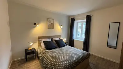 a bedroom with a bed with two pillows and a window at My Agradi, Maison de village in Les Martys