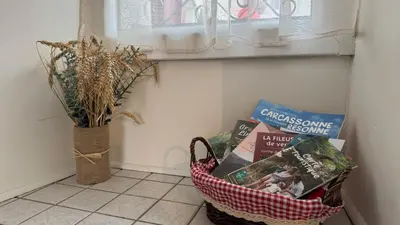 a basket of books sitting on a floor next to a window at My Agradi, Maison de village in Les Martys
