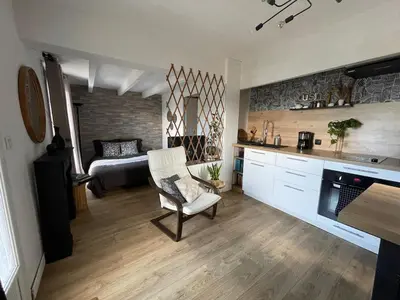 a bedroom with a bed and a chair in a room at Logement Idéal pour un couple in Puisserguier