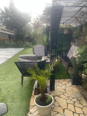 a patio with a table and a chair and plants at Logement Idéal pour un couple in Puisserguier