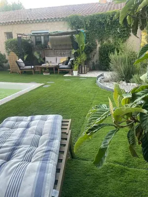 a bed sitting in a yard next to a garden at Logement Idéal pour un couple in Puisserguier