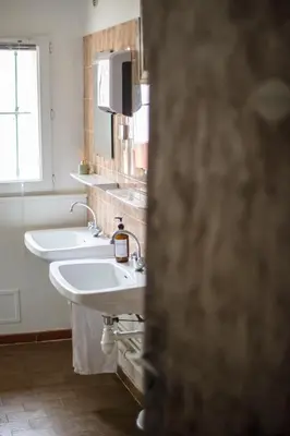 a bathroom with two sinks and a window at Domaine Castelnaut gîte et château in Laroque-de-Fa