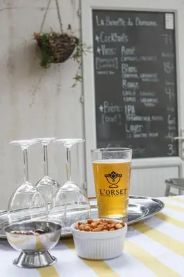 a table with a glass of beer and a bowl of food at Domaine Castelnaut gîte et château in Laroque-de-Fa
