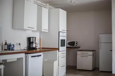 a kitchen with white cabinets and a white refrigerator at Domaine Castelnaut gîte et château in Laroque-de-Fa