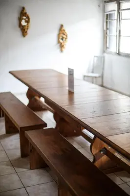 a wooden table and benches in a room at Domaine Castelnaut gîte et château in Laroque-de-Fa