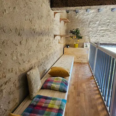 a room with a bench with a pillow on it at L'intendance - calme et cosy, vieilles pierres in Saint-Félix-Lauragais