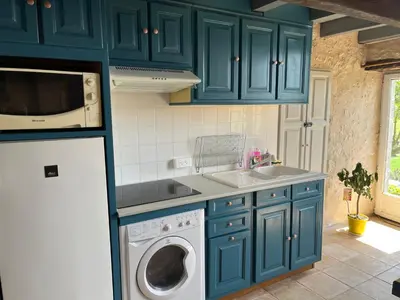 a kitchen with blue cabinets and a washing machine at L'intendance - calme et cosy, vieilles pierres in Saint-Félix-Lauragais