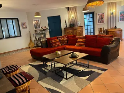 a living room with a red couch and a table at Magnifique et grand loft classé 4 étoiles in Lavelanet