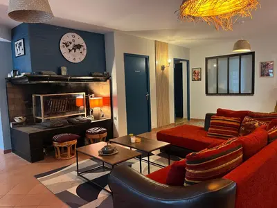 a living room with a red couch and a fireplace at Magnifique et grand loft classé 4 étoiles in Lavelanet