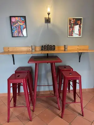 a wooden table with two red stools under it at Magnifique et grand loft classé 4 étoiles in Lavelanet