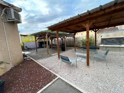 a patio with two chairs and a wooden pergola at Magnifique et grand loft classé 4 étoiles in Lavelanet