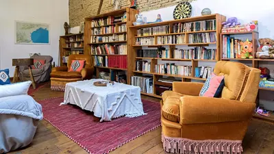 a living room with a couch and a wooden wheel at Chambres et appartement de charme dans ferme de caractère - billard, jardin et cheminée - près du Canal du Midi in Lagarde