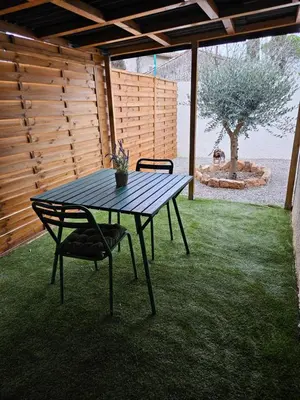 a picnic table and two chairs in a yard at Le Nid de Moline 3 étoiles in Villemoustaussou