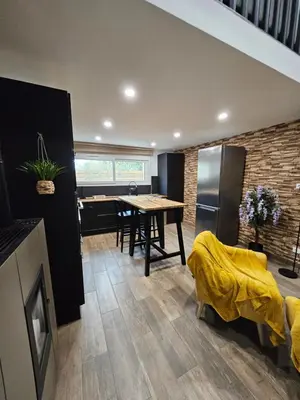 a kitchen and dining room with a table and a refrigerator at Le Nid de Moline 3 étoiles in Villemoustaussou