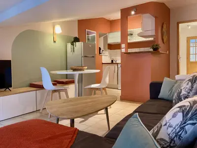 a living room and kitchen with a couch and a table at L'Escale médiévale in Carcassonne
