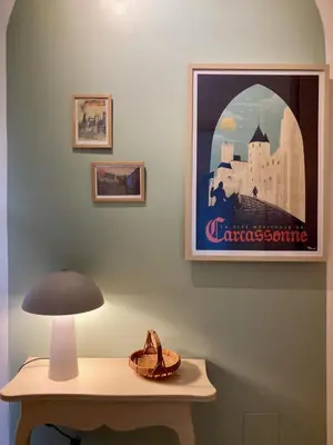a table with a lamp and a picture on the wall at L'Escale médiévale in Carcassonne