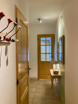 a hallway with a door and a table with a lamp at L'Escale médiévale in Carcassonne